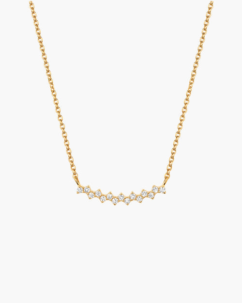 Collar Aria en blanco, barra curva en tono dorado con una fila de piedras redondas transparentes, en cadena de eslabones