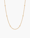 Bella Necklace, thin gold-tone snake chain with evenly spaced polished gold beads, on white